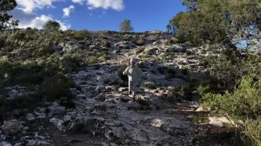 Beyaz kız çam ormanlarında dağ yolunda koşuyor. Çocuk açık havada yürüyüş yapmayı seviyor. Geniş açı