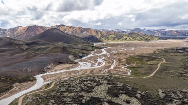 Renkli rhyolite tepeleri, örülmüş nehirler, volkanik kaya oluşumları ve kar tepelerinin yer aldığı Landmannalaugar, İzlanda 'nın hava perspektifi.