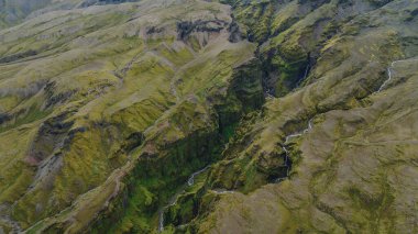 İzlanda 'da sarp yosunlarla kaplı uçurumlar, derin yarıklar ve manzarayı saran dar dereler içeren dramatik bir kanyon manzarası..