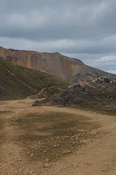 Landmannalaugar, İzlanda 'da bulutlu bir gökyüzünün altında, volkanik kayalar ve çorak arazide rüzgarlar esiyor..