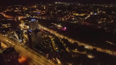 Vilnius, Litvanya 'nın gece hava manzarasında Radisson Blu Oteli, Neris Nehri ve modern ve tarihi mimarinin bir karışımı yer alıyor..