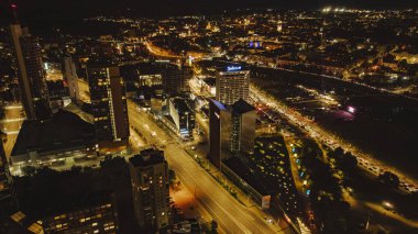 Vilnius, Litvanya 'nın aydınlanmış şehir manzarası, Radisson Blu Hotel, modern yüksek binalar, Neris Nehri, ve gece tarihi Eski Şehir.