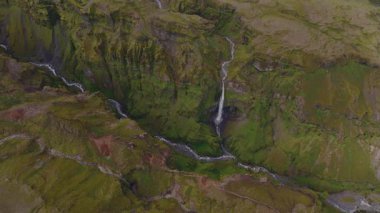 İnsansız hava aracı İzlanda 'daki yeşil kanyonların üzerinde süzülerek çağlayan şelaleleri ve engebeli arazinin ortasındaki bir buzulu gözler önüne seriyor..