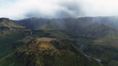 İnsansız hava aracı İzlanda 'daki yemyeşil bir vadiyi süpürüyor, dolambaçlı bir nehri, dramatik dağları ve el değmemiş çöllerdeki uzak kar zirvelerini ortaya çıkarıyor..