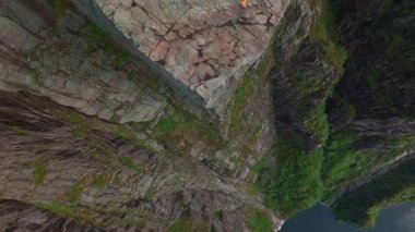 Norveç 'te bir uçurum olan Preikestolen' in hava görüntüsü, düz kaya yüzeyini, bitki örtüsünü ve Lysefjord 'u kademeli drone hareketiyle gösteriyor..