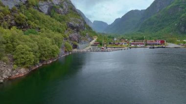 İnsansız hava aracı Lysebotn, Norveç üzerinde hareket ediyor. Uçurumlar, fiyortlar, marinalar, kırmızı çatılar ve yemyeşil alanlarla çevrili bir vadi ortaya çıkıyor..