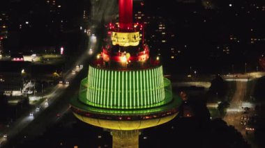 Litvanya 'daki Vilnius TV Kulesi geceleri yeşil ve kırmızı ışıklarla aydınlatılır. Yavaş bir tava ya da yakınlaştırma parlayan bir kuleyi ve şehir manzarasını ortaya çıkarır.