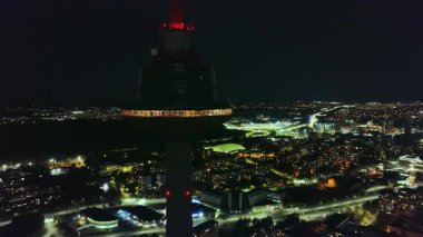 Vilnius TV Kulesi geceleri kırmızı ışıklarla parlar ve karanlık bir gökyüzüne karşı dik dururlar. Kamera Vilnius, Litvanya 'nın aydınlık şehir manzarasını gözler önüne seriyor..