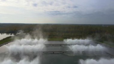 İnsansız hava aracı, Minsk, Belarus yakınlarındaki bir ormanı, uzakta küçük bir yerleşim yeri ve manzarayı çevreleyen ağaç tepeleriyle görüntüler..