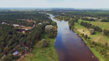 İnsansız hava aracı, Polonya 'nın Nowy Lubiel kentinden akan bir nehri, tarlaları, ormanları ve bir tarafında evler ve bahçelerin bulunduğu bir yerleşim bölgesini ele geçirdi..