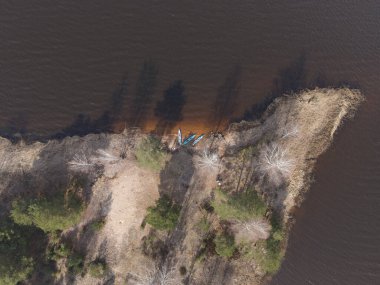 Beyaz Rusya 'nın Berezivka veya Minsk yakınlarındaki karanlık sulara uzanan seyrek yapraksız, dar bir yarımadanın havadan görünüşü. Kanolar kıyıda görülebilir..