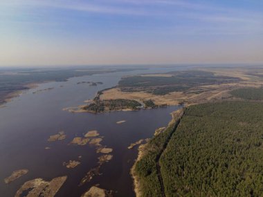 Beyaz Rusya 'nın Minsk kenti yakınlarındaki kozalaklı ormanlar ve açık arazilerle çevrili küçük adaları olan bir nehrin sakin hava manzarası..