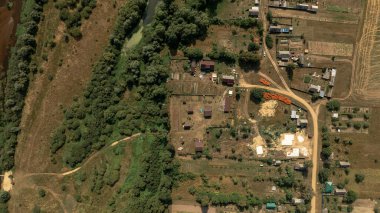 Beyaz Rusya 'da dolambaçlı bir nehir, yoğun bitki örtüsü, dağınık evler, bahçeler, toprak yollar ve tarım arazileri olan bir kırsal bölge ele geçirir..