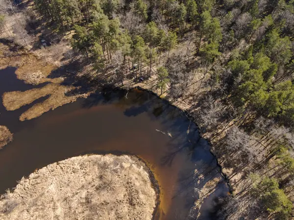 İnsansız hava aracı, mevsimsel geçiş döneminde Berezivka veya Minsk yakınlarındaki karışık ağaçlar ve seyrek ormanlarla çevrili yansıtıcı suyla dolambaçlı bir nehri yakalar..