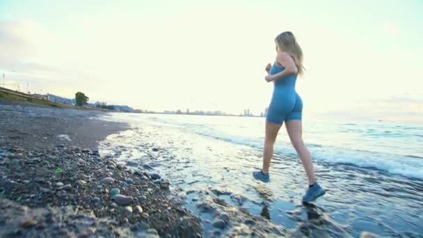 Spor Kıyafetleri Içinde Güzel Bir Atletik Kız Plaj Boyunca Koşar — Stok video