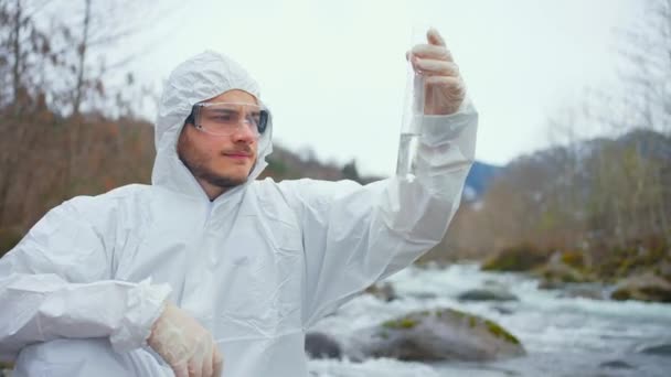 Dissatisfied Biologist Protective White Jumpsuit Tests Water Quality River — Stockvideo
