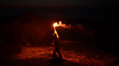 a lone person traveler in yellow wind protection gives a Help signal at night signal SOS