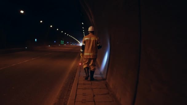 白い硬い帽子に身を包んだ労働者がトンネルの地下を調べて壁を調べ — ストック動画