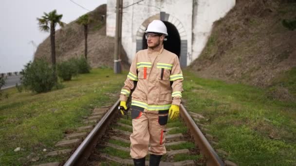 鉄道技術者の従業員がトンネルを背景に線路の状態を調べ — ストック動画