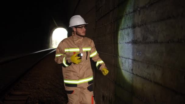 鉄道技師の手に提灯を持った労働者がトンネルの壁の状態を調べ — ストック動画