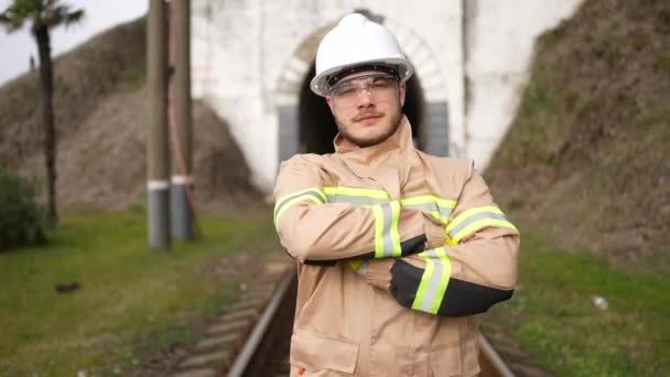 カメラを覗き込むトンネルを背景にした前向きな笑顔の鉄道技師の肖像画です — ストック動画