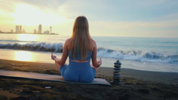 日落时分 一位身材苗条的年轻女子在海滨练习瑜伽或冥想 — 图库视频影像