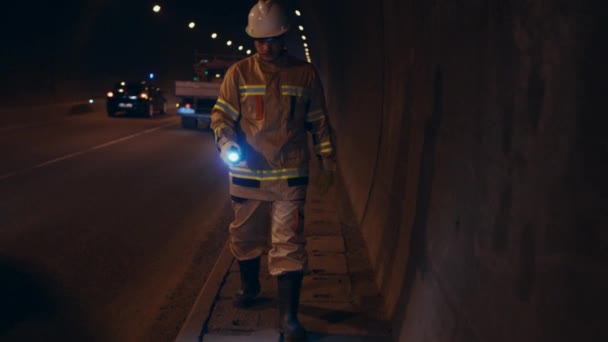 白い硬い帽子に身を包んだ労働者がトンネルの地下を調べて壁を調べ — ストック動画