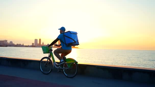 Entregador Positivo Uniforme Azul Com Uma Mochila Monta Uma Bicicleta — Vídeo de Stock