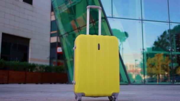 Einsamer Gelber Koffer Ohne Menschen Vor Dem Hintergrund Moderner Glasbauten — Stockvideo