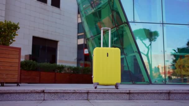 Einsamer Gelber Koffer Ohne Menschen Vor Dem Hintergrund Moderner Glasbauten — Stockvideo