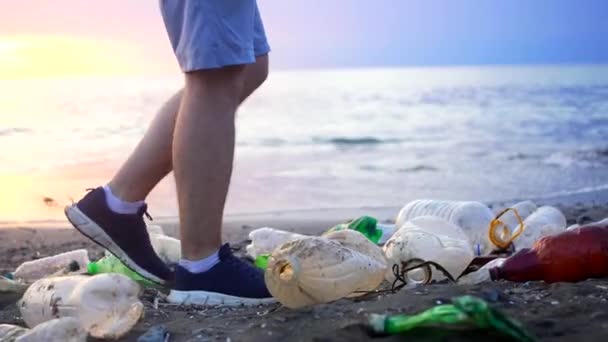 プラスチックごみの問題の概念 世界の汚染 海岸に沿って歩く男の足 — ストック動画