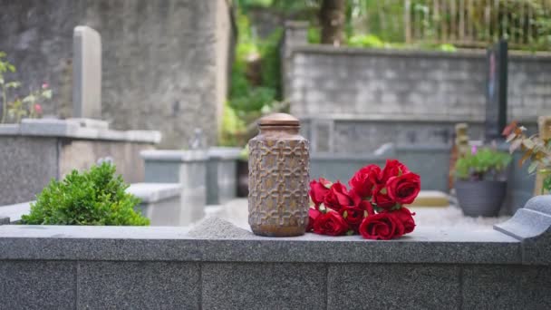 坟场背景上的骨灰和花卉骨灰的骨灰盒 葬礼的火葬仪式 — 图库视频影像