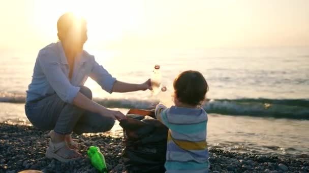 Маленький Ребенок Помогает Матери Волонтерше Собирать Пластиковый Мусор Побережье Океана — стоковое видео