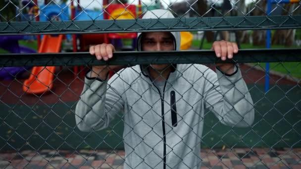 Krimineller Mann Mit Kapuze Schaut Auf Spielplatz — Stockvideo