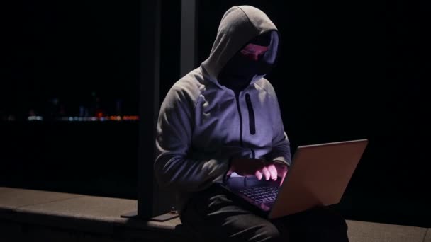 Geceleyin Kar Maskeli Bir Haydut Sokakta Dizüstü Bilgisayar Kullanıyor — Stok video
