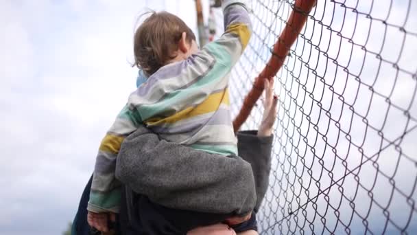 栅栏边的一个无法辨认的母亲和孩子 越过了边境难民问题 — 图库视频影像