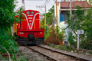 Dar bir sokaktan geçen trenin inanılmaz manzarası, Hanoi Eski Mahallesi. Trenin fotoğraflarını çeken turistler..