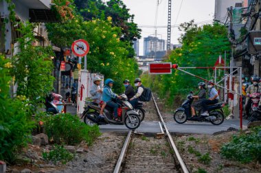 Ho Chi Minh, Viet Nam - 8 Nisan 2023: Dar bir sokaktan geçen trenin inanılmaz manzarası, Hanoi Eski Mahallesi. Trenin fotoğraflarını çeken turistler. Hanoi Tren Sokağı popüler bir yerdir.