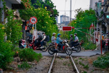 Ho Chi Minh, Viet Nam - 8 Nisan 2023: Dar bir sokaktan geçen trenin inanılmaz manzarası, Hanoi Eski Mahallesi. Trenin fotoğraflarını çeken turistler. Hanoi Tren Sokağı popüler bir yerdir.