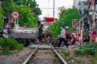 Ho Chi Minh, Viet Nam - 8 Nisan 2023: Dar bir sokaktan geçen trenin inanılmaz manzarası, Hanoi Eski Mahallesi. Trenin fotoğraflarını çeken turistler. Hanoi Tren Sokağı popüler bir yerdir.