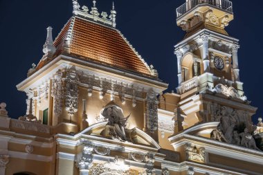 Ho Chi Minh, Viet Nam - 10 Nisan 2023: Saigon Belediye Binası, Vincom Merkezi kuleleri, muhteşem geceye karşı renkli sokak trafiği ve tropikal bitkiler. Saigon şehir merkezinin ünlü simgeleriyle.