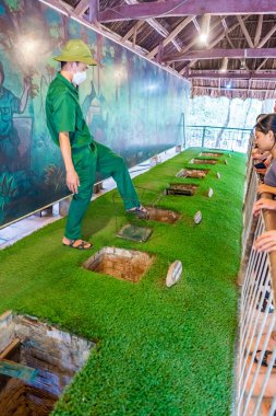 Cu Chi, Viet Nam - 20 Mayıs 2023 Cu Chi tünelleri. Tuzağı Cu Chi tünellerinde kullandıklarını gösteren personel. Vietnam savaşında kullanılıyor. Vietnam 'ın ünlü turistik merkezi.