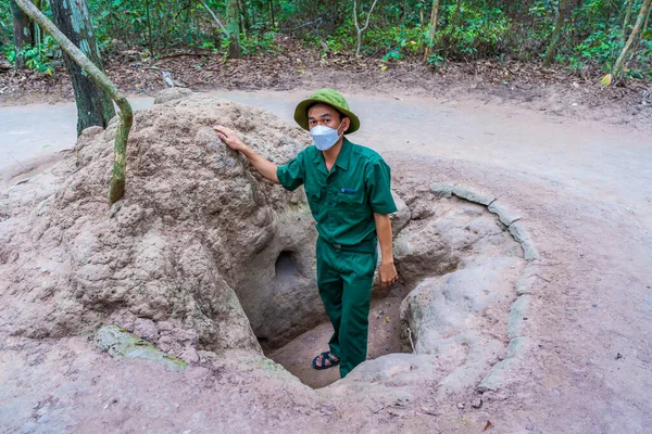 stock image Cu Chi, Viet Nam - 20 May 2023: The Cu Chi tunnels. A guide demonstrating how a Vietcong hide into the Tunnel. It's used in Vietnam war. Famous tourist attraction in Vietnam