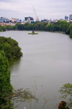 Hanoi, Viet Nam - 13 Mayıs 2023: Hoan Kiem Gölü 'nün havadan görünüşü - Ho Guom ya da Sword Gölü' nün ortasında sabah sisli havada. Hoan Kiem Gölü Hanoi 'de ünlü bir turistik yerdir. Seyahat ve manzara konsepti. Seçici odak.