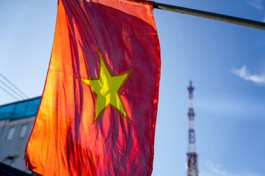 Rüzgarda dalgalanan Vietnam bayrağı mavi bir gökyüzü arka planına karşı