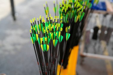 Renkli okçuluk okları grubu, ipin üzerine yapışmış ve oku yerinde tutan delikli plastik uçlar olan plastik kanatlar ya da tüyler olan fletch 'leri gösteriyor..