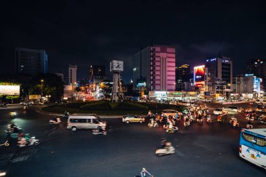 Ho Chi Minh City, Vietnam - 14 Nisan 2023: Ho Chi Minh şehrinin bir sembolü olan dört yüzlü saat kulesiyle Dien Bien Phu kavşağında trafik sıkışıklığı. Arabalardan hafif yol.