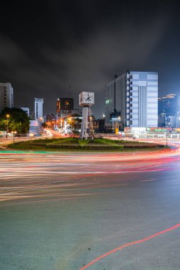 Ho Chi Minh City, Vietnam - 14 Nisan 2023: Ho Chi Minh şehrinin bir sembolü olan dört yüzlü saat kulesiyle Dien Bien Phu kavşağında trafik sıkışıklığı. Arabalardan hafif yol.