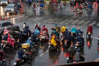 Ho Chi Minh, Viet Nam - 24 Nisan 2023: Vietnamlı taçlandırılmış insanlar yoğun yağmur ve trafik sıkışıklığında kask ve yağmurluk giyerler. Saygon, Vietnam 'da yağmur mevsimi.