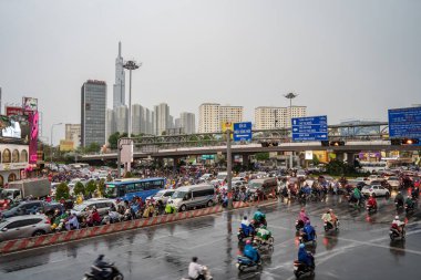 Ho Chi Minh, Viet Nam - 24 Nisan 2023: Vietnamlı taçlandırılmış insanlar yoğun yağmur ve trafik sıkışıklığında kask ve yağmurluk giyerler. Saygon, Vietnam 'da yağmur mevsimi.